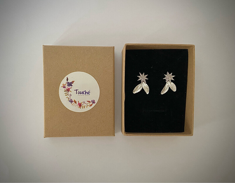 Pendientes con forma de estrella de unos 2 cm de largo y 1 cm de ancho en tonalidad plateada. Compuestos por estrella con pequeños cristales y una hoja en plata clara.

Son desmontables, se pueden usar sólo las estrellas o las estrellas y el colgante de hojas.