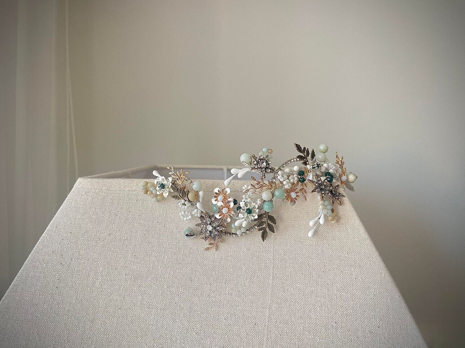 Tocado joya de unos 18 cm de longitud aproximadamente compuesto por múltiples elementos de metal, porcelana, cristales y piedras. Una ramita llena de alegría con mucha versatilidad para poder ser utilizada en múltiples posiciones.

Este tocado de novia puede elaborarse en otros tonos ajustándose a tus complementos y a tu look. ¡No dudes en consultar por otros posibles tamaños!