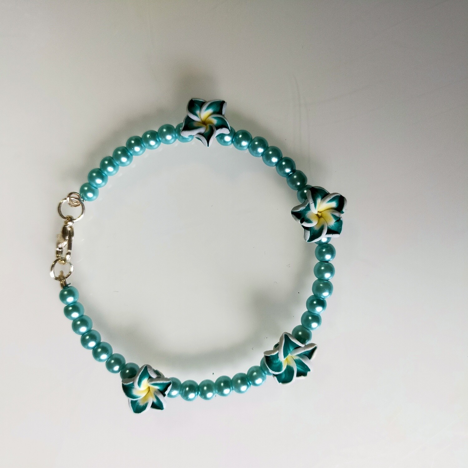 Armband mit Perlen und vier Blumen in verschiedenen Farben 