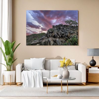 Canvas print of rocky hill at sunset with dramatic purple sky, adding art to living room
