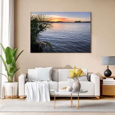 Flores - Sunset Reflections at Lago Petén Itzá Canvas print of lakeside sunset with palm leaves, adding tropical art to cozy living room