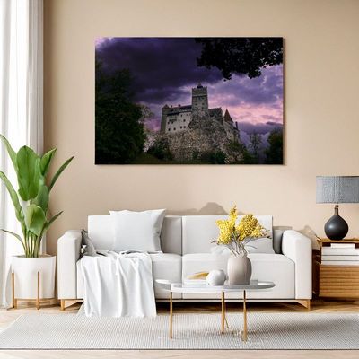 Bran Castle - Origin of Myths and Legends Bran Castle print on wall with moody purple sunset in stylish living space.