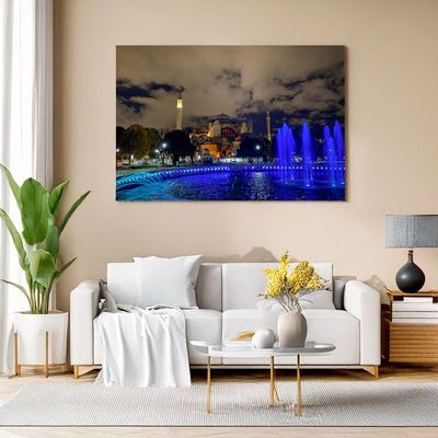Istanbul - Nighttime View of Hagia Sophia Wall art in a modern living room featuring a nighttime photo of Hagia Sophia in Istanbul with a blue-lit fountain in the fore