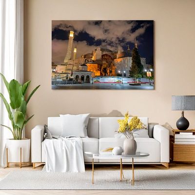 Wall art above a white sofa shows Hagia Sophia in Istanbul at night, warmly illuminated with a dramatic cloudy sky.