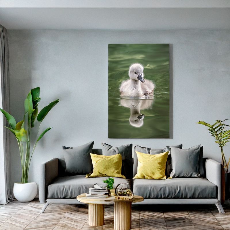 Modern living room with grey sofa, canvas of fluffy cygnet on green water, stylish decor.