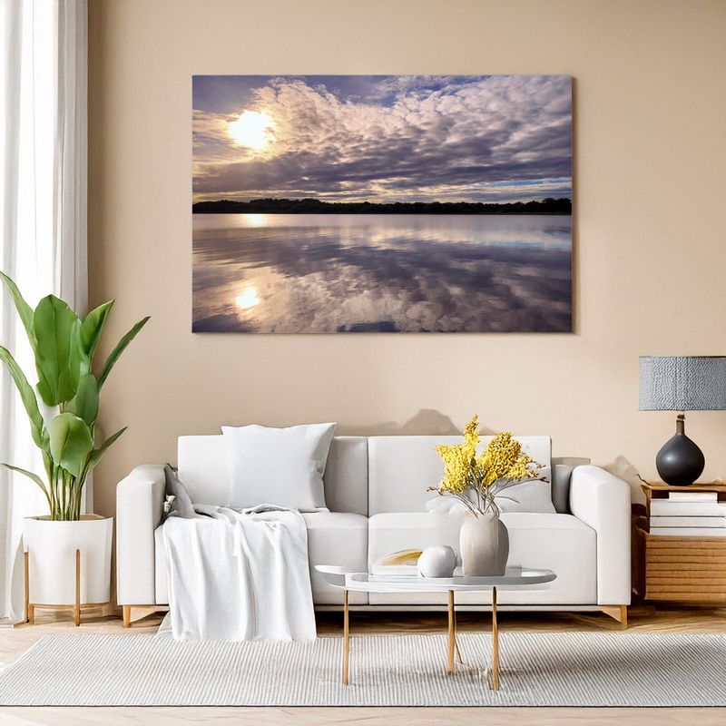 Stilvolles Wohnzimmer mit Leinwand eines Sonnenuntergangs über ruhigem See