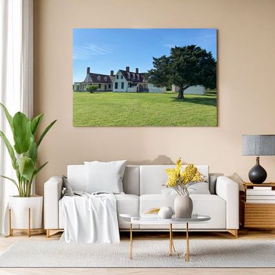 Gerahmtes Landschaftsbild mit historischem Haus über Sofa in modernem Wohnzimmer