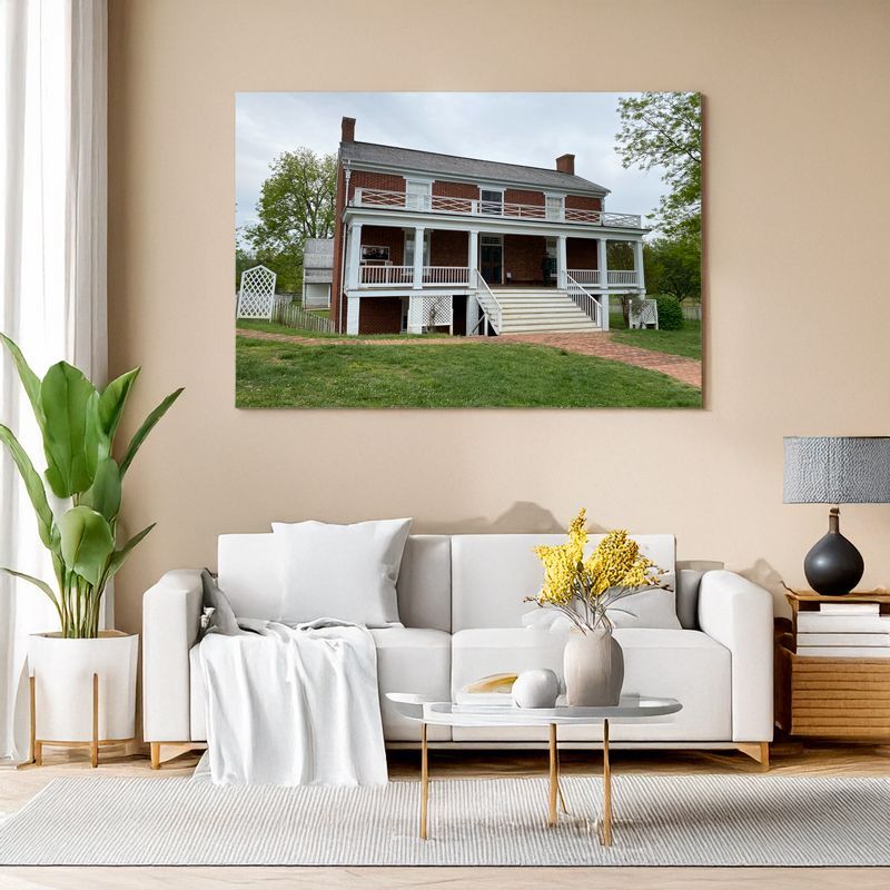 Gerahmtes Landschaftsbild mit zweistöckigem Backsteinhaus über Sofa in modernem Wohnzimmer