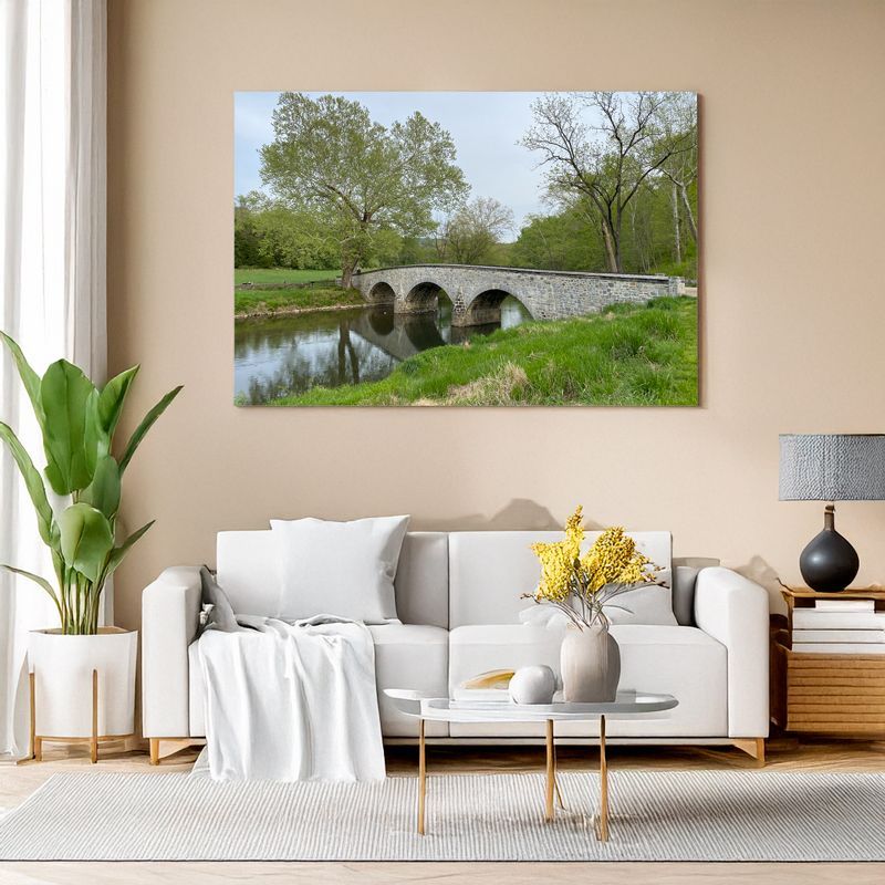 Gerahmtes Landschaftsbild mit Steinbrücke über Sofa in modernem Wohnzimmer