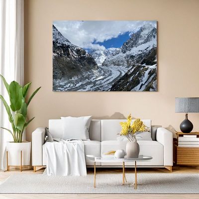 Wohnzimmer mit Leinwandbild einer Gletscherlandschaft zwischen hohen Bergen.