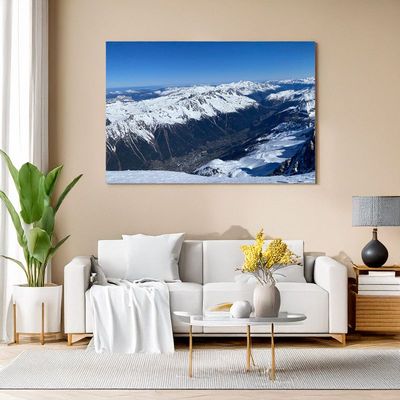 Wohnzimmer mit Leinwandbild einer Berglandschaft aus der Vogelperspektive.