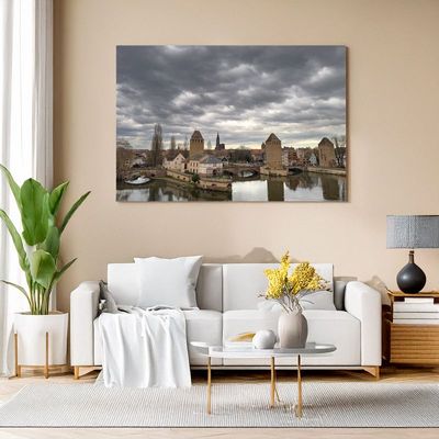 Leinwand im Wohnzimmer mit Flusslandschaft und historischen Türmen.