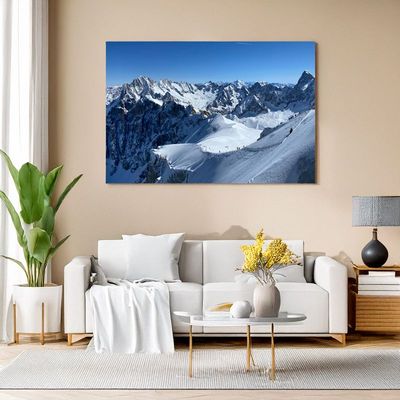 Wohnzimmer mit Leinwandbild von Bergsteigern auf einem schneebedeckten Grat.