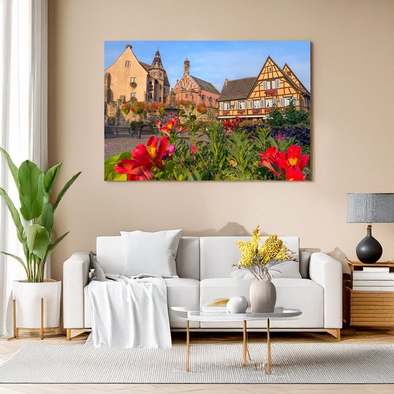 Leinwand im Wohnzimmer zeigt Dorfplatz mit Fachwerkhäusern und Blumen.