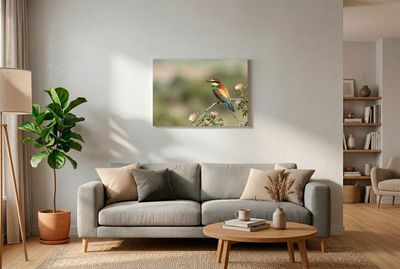 Bienenfresser sitzt im Profil auf einem Ast mit rosafarbenen Blüten vor ruhigem Hintergrund.