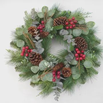 24 inch Christmas wreath made of artificial pine, eucalyptus, and red berries hanging on front door
