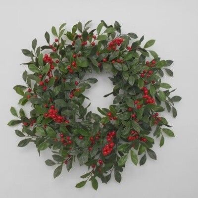 20 inch artificial Christmas wreath made of red berries and green leaves hanging on a door
