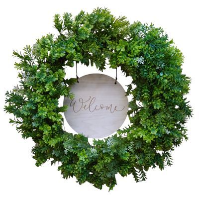 22 inch boxwood wreath with welcome wooden sign hanging on a front door
