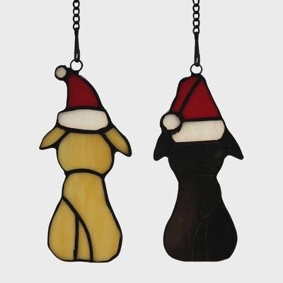 Stained glass panel of white and black pups in red holiday hats on white background