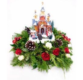 Light-up Caroling Church with evergreens, roses, pinecones, and rotating Christmas carolers
