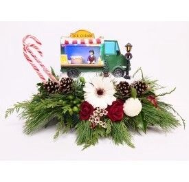 Light-up Holiday Ice Cream Truck sitting on fresh Christmas bouquet with roses and gerbera
