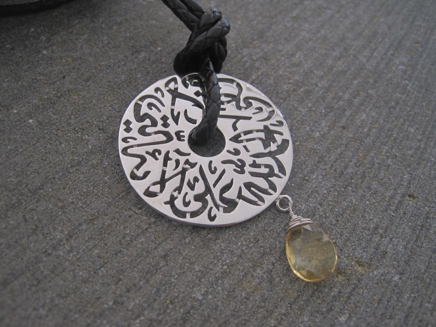 LONG BRAIDED LEATHER NECKLACE WITH LARGE DISC AND HAND CUT STONE