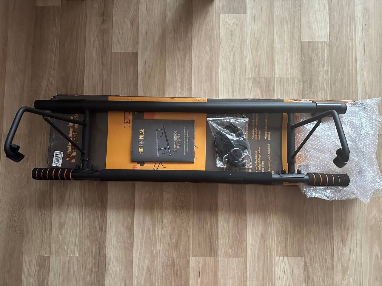 High Pulse Drążek do Podciągania z hakami, karabińczykiem, pętlami i plakatem.