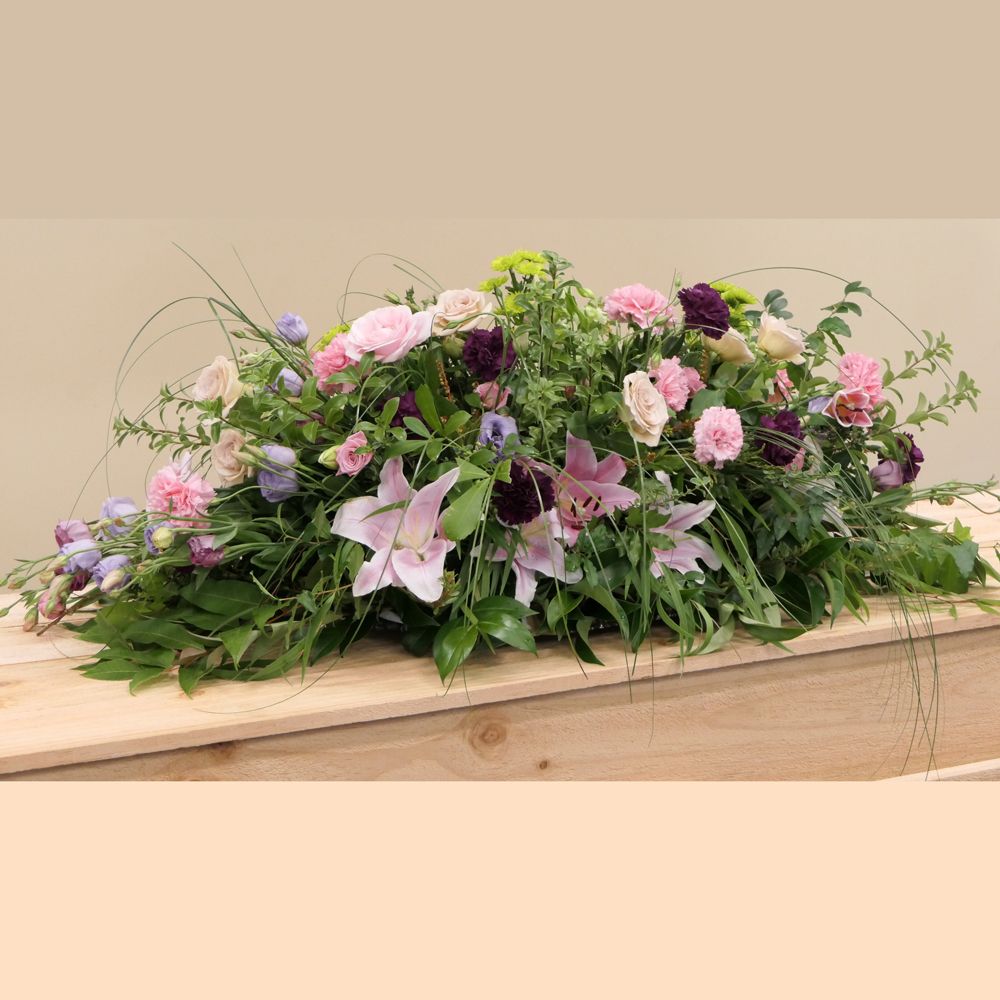 Composition florale champêtre rose et parme sur un cercueil, pour un deuil
