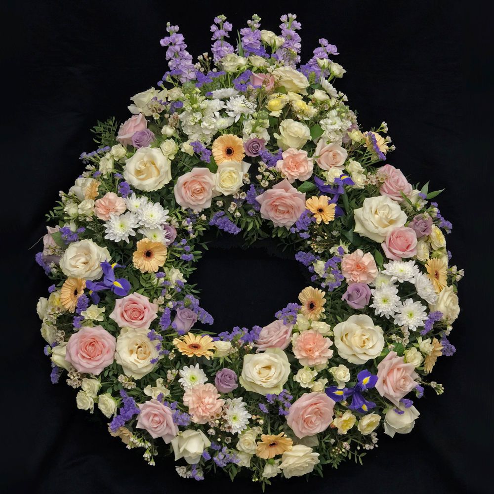 Couronne de fleurs pour un deuil, tons rose, blanc, pêche et parme