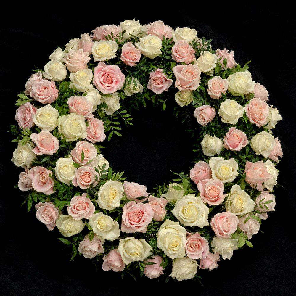 Couronne funéraire de roses blanches et roses sur fond noir
