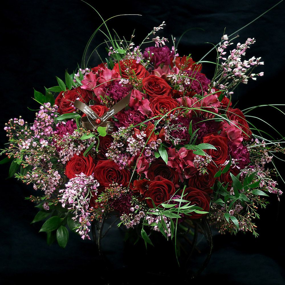 Un somptueux bouquet de roses rouges et de fleurs roses, symbole d'amour et de beauté, éveille les sens avec élégance.