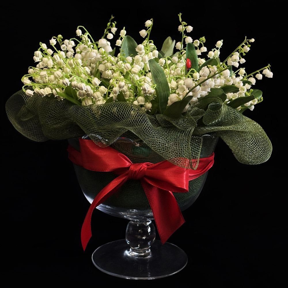 Composition florale de muguet blanc en coupe de verre avec ruban rouge