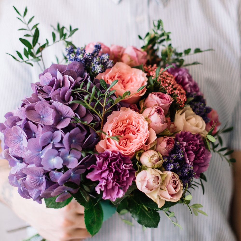 Bouquet rond aux tons violet, rose poudré et pêche avec hortensia et roses