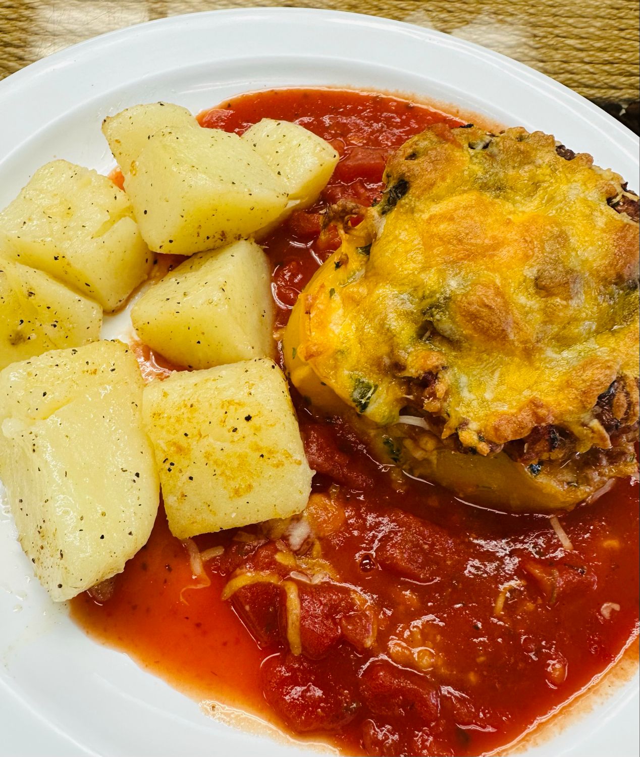 Stuffed bell peppers filled with seasoned ground beef, finished in a rich tomato-herb sauce and served with tender potatoes.