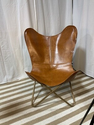 Faux leather butterfly chair with gold legs.