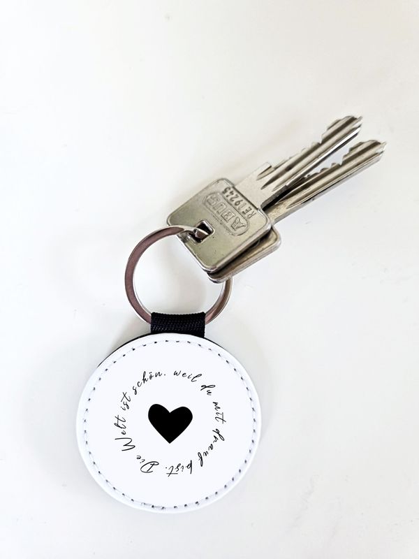 Handgefertigter Schlüsselanhänger mit Spruch „Die Welt ist schön, weil du mit drauf bist“ aus veganem Leder Handgefertigter Schlüsselanhänger mit Spruch „Die Welt ist schön, weil du mit drauf bist“ aus veganem Leder