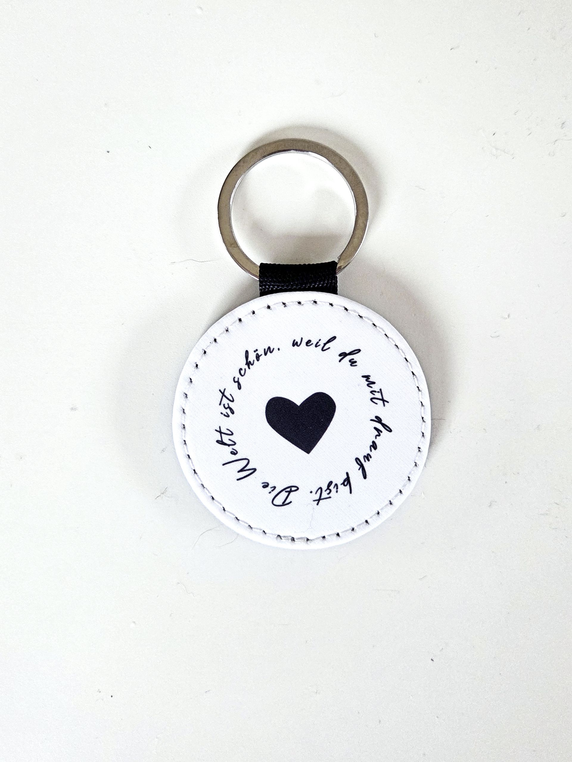 Handgefertigter Schlüsselanhänger mit Spruch „Die Welt ist schön, weil du mit drauf bist“ aus veganem Leder