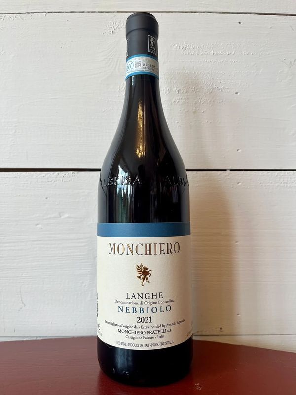 Bottle of red wine with white wall in the back