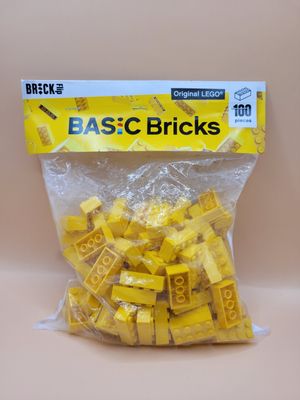 Zak met 100 gele LEGO bouwstenen.