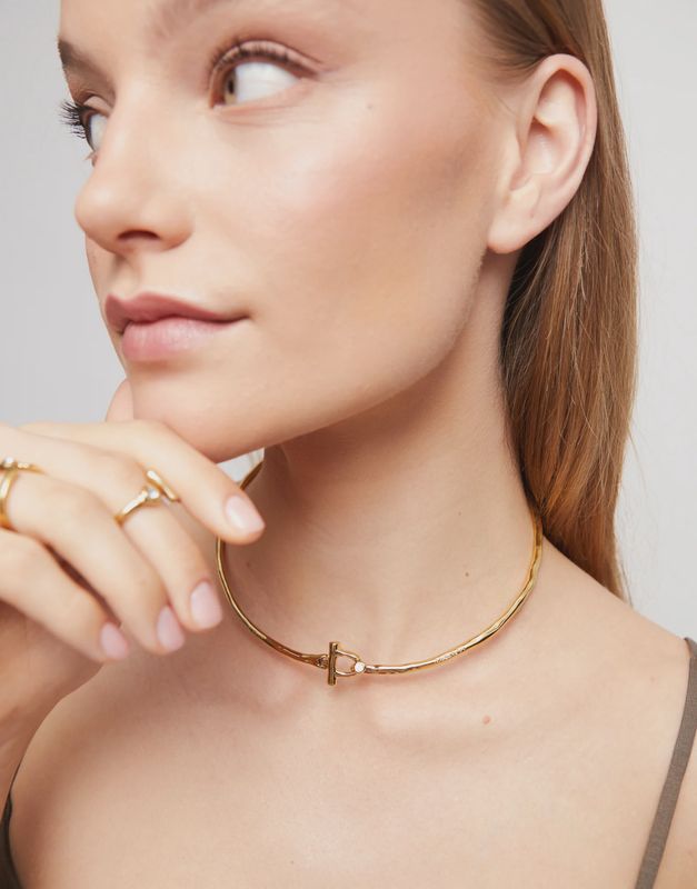 Rigid necklace in gold with white topaz