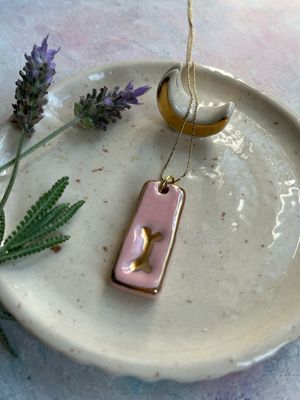 Dije huesito con inicial personalizado