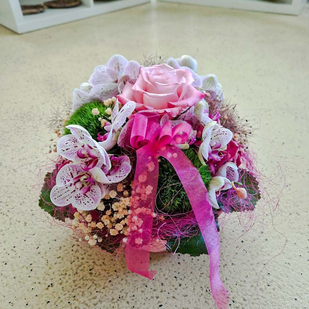 Hübsches Gesteck mit Orchideen und Schleife in Korb, rosa, weiss