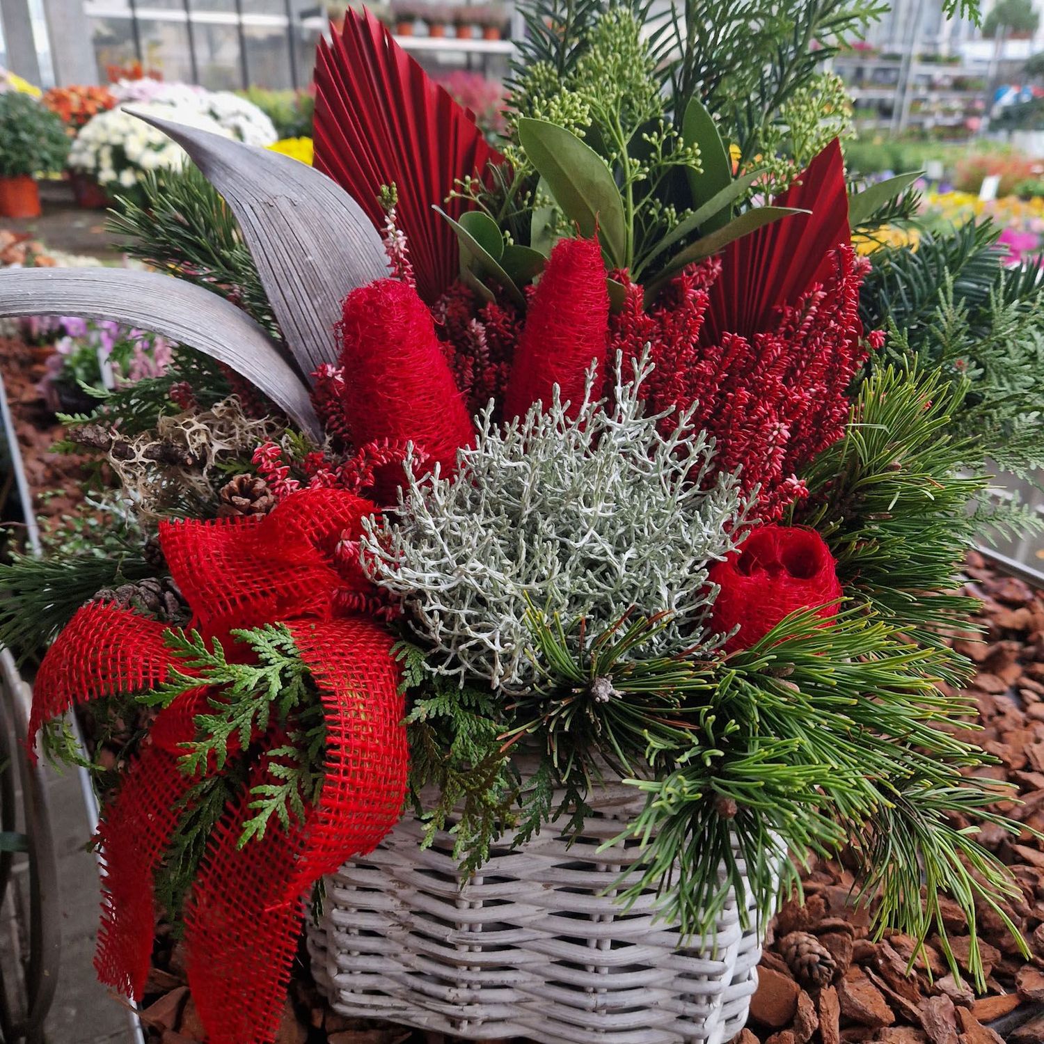 Korbarrangement mit rotem Winterschmuck