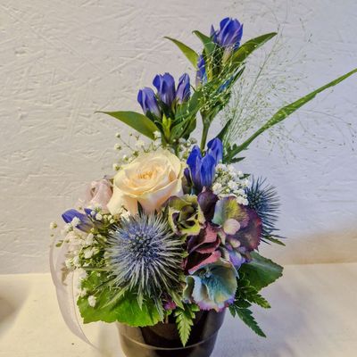 Gestuftes Gesteck mit Enzian und Distel, blau/weiss/gelb