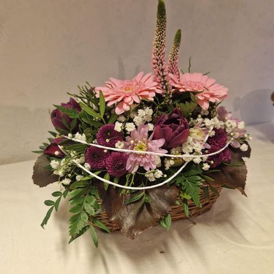 Gesteck in Korb, mit kräftigen Farben, lila, rosa, grün