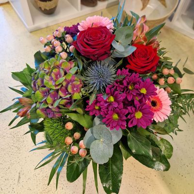 Kräftige Farben: kompakter Strauss in rot/lila/rosa und mit verschiedenen Blättern
