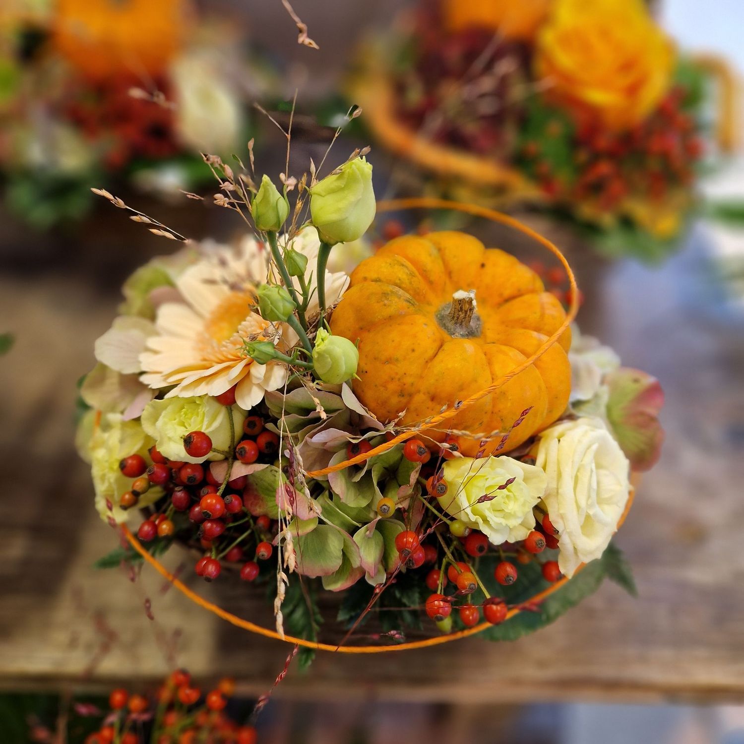 Herbstliches Gesteck mit Deko-Kürbis, orange/gelb/rot, in Korb