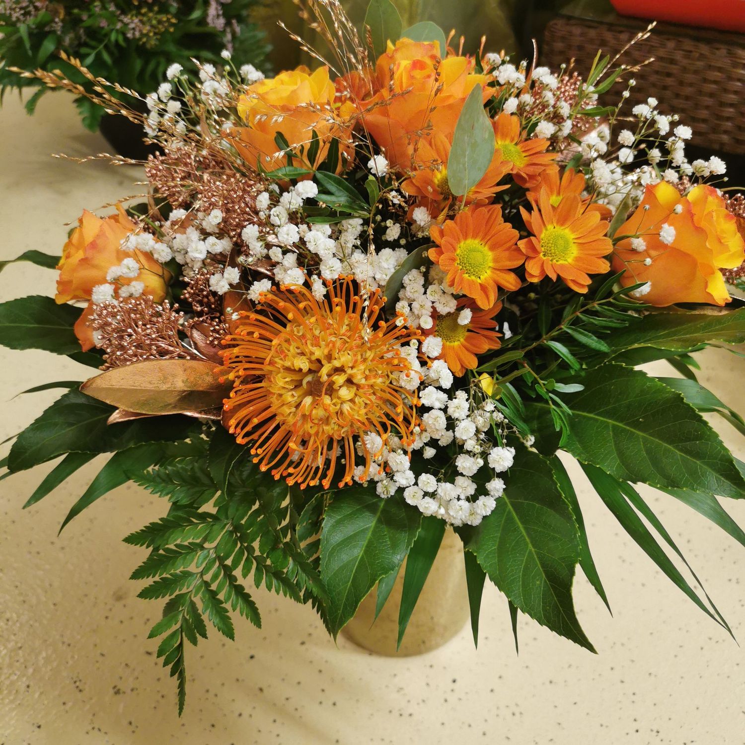Vorweihnächtlicher glitzernder Strauss mit Rosen und Schleierkraut, orange/gelb Vorweihnächtlicher glitzernder Strauss mit Rosen und Schleierkraut, orange/gelb