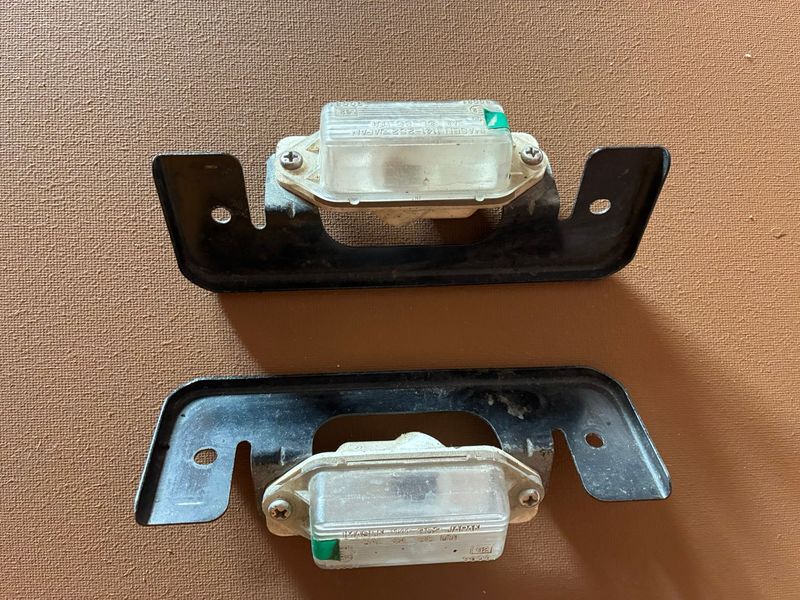 MB623967 (8341A099) + MR574339 - Kennzeichenbeleuchtung + Halter, gebraucht