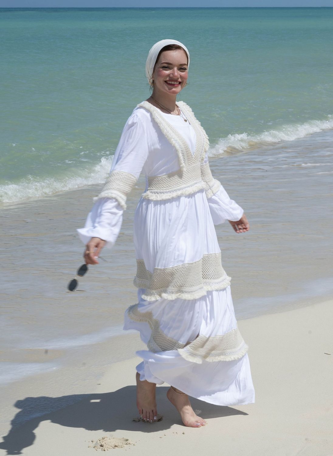 "Model wearing a Adorned Bohemian White Maxi Dress on the beach"